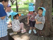 木陰で休憩をする子どもの写真