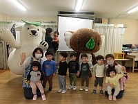 写真:エコクマと一緒に写真撮影する1歳児