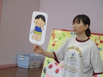 プールの諸注意をペープサートを使って説明する保育士の写真