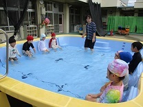 水の冷たさに徐々に体を慣らす4歳児の写真