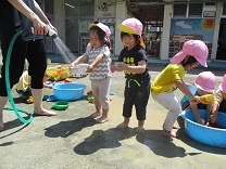 シャワーから水をもらう2歳児の写真