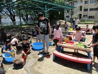 写真：5歳児が水や泥を使ってままごとあそびを楽しんでいる様子