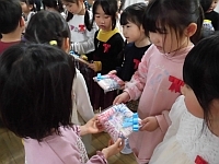 写真:卒園プレゼントを渡している様子