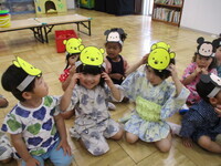 お面をかぶっている2歳児の写真