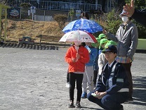 傘を持って横断歩道を渡る練習をしている様子の写真