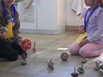 子どもたちがコマをする様子の写真