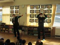 子ども110番の家のステッカーを見せる日野警察署のお巡りさんの写真