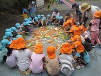 みんなでぼかしを混ぜた野菜くずを見ている様子の写真