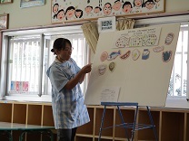 栄養の歌のパネルシアターをする保育士の写真