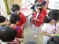 お土産のメダルを渡す子供の写真