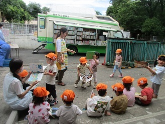 3歳児こあら組がひまわり号で絵本を借りている様子の写真