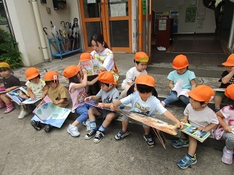 3歳児こあら組がひまわり号で借りた絵本を見ている様子の写真