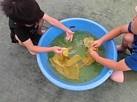 写真:染まった布を洗っているところ