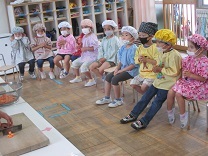 手を清潔に保つためお祈りポーズで切る順番を待つ4才児クラスの様子の写真