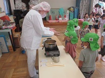 鍋に近づき、においをかぐ3歳児の写真