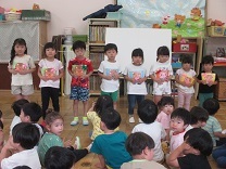 誕生カードを受け取り喜ぶ子どもたちの写真