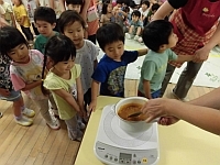 写真:デモンストレーションで作ったカレーを見ている様子