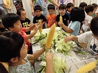 写真:皮がむけたとうもろこしを見せている様子