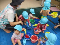 水遊びを楽しむ1歳児の様子の写真