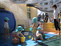 水遊びをしている1歳児の様子の写真