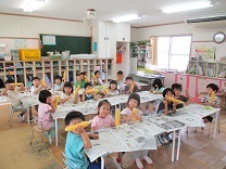 トウモロコシの皮をむく4歳児