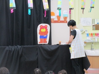 ペープサートでプールの約束を伝えている様子の写真