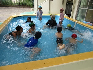 プール閉いでどのくらい泳げるようになったか友達と見せ合いっこしている様子の写真