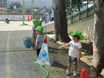 暑いのでミストを浴びながら運動会の練習に取り組む子供の写真