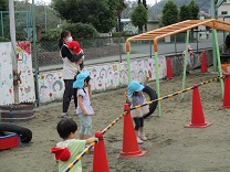 年長組のひのソングをまねして踊る3歳児の写真