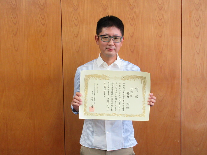 写真:新規就農者が賞状を持っている様子