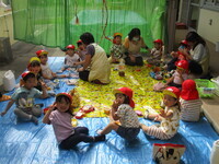 座ってお弁当を食べている子どもの写真