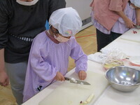 包丁を使って野菜を切っている様子の写真