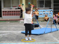 マラカスもって、マッスルポーズをしている子供の写真