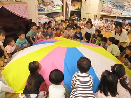 写真:うさぎ組がきりん組のパラバルーンをやっています