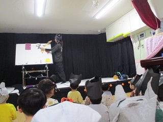 写真:ホールでハロウィンのパネルシアターを見ています