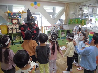 写真:魔女の格好をした職員にトリックオアトリートと声をかけています