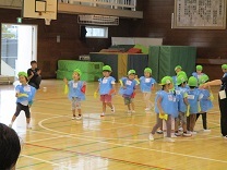 両手に旗をつけて踊る3歳児の写真