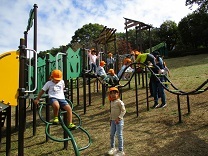 遊具に乗ってはしゃぐ5歳児の写真