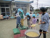 大鍋の中を覗いてみる子どもの写真