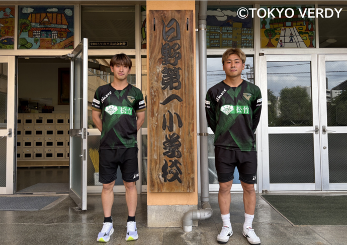 熊取谷選手と新井選手　学校の看板前での写真