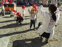 お弁当バスの手遊びをする1歳児の写真