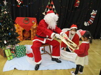 サンタさんからプレゼントをもらっている様子の写真