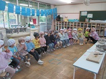 写真：調理保育の説明を真剣に聞く4歳児