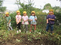 写真：長いツルをもって引っ張る五歳児