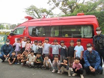 写真：消防署指揮車と消防士さんと記念撮影（5歳児）
