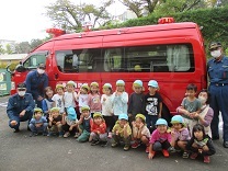 写真：消防署指揮車と消防士さんと記念撮影（4歳児）