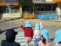 手を挙げて横断歩道を渡っている様子の写真