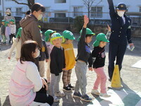 手を挙げて横断歩道の渡り方を確認している4歳児の様子の写真
