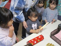 おみくじを引いている2歳児の様子の写真