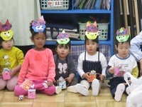 お面をかぶっている2歳児の様子の写真